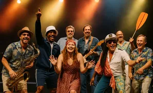 Band of musicians smiling and laughing on stage.