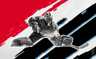 A hockey goalie in a crouched position, ready to make a save.