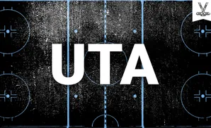 Top-down view of a distressed, black hockey rink with blue markings and a white banner with crossed hockey sticks.