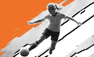 A female soccer player kicks a ball while in mid-air, with an orange graphic design behind her.