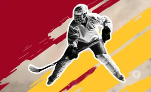 A hockey player in full gear skates with a stick.