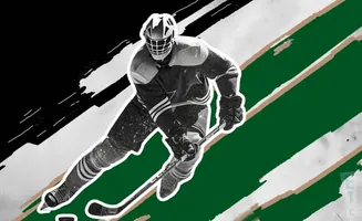 A hockey player in a dark uniform skates with a stick.