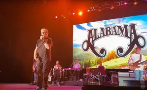 Lead singer of Alabama on stage, holding a microphone.