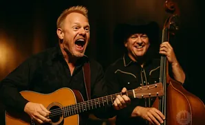 Two men play music: one sings and plays guitar, the other plays upright bass.