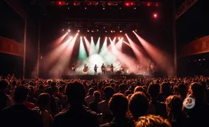 A band plays on a smoke-filled stage to a cheering crowd at a concert.