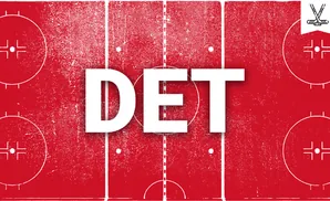 Red ice hockey rink with white markings, including face-off circles and center ice line.