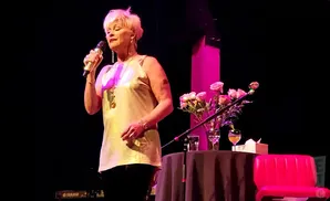 lorrie morgan singing on stage in front of pink roses