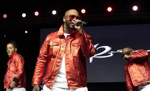 Rapper The Game and backup dancers perform on stage in matching red jackets.