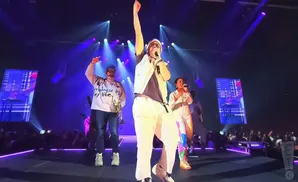 tobymac performing on stage wearing a beanie and glasses