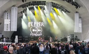 A band named Pepper performs on stage with lights and speakers.