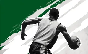 Black and white image of a basketball player dribbling a ball with green and white brush strokes in the background.