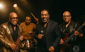 A jazz band performs with a saxophonist, singer, bassist, and drummer.