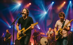 A band performs live on stage with bright colorful lights.