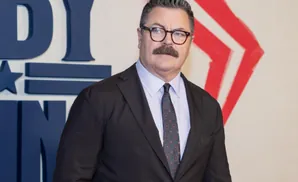 Man with mustache and glasses wearing a suit and tie.