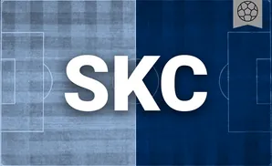 a sporting kansas city soccer player kicking the ball down field 