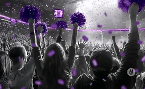 Crowd cheering with purple pom-poms and confetti.