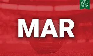 A red-tinted globe sits on grass with a blurred stadium in the background, a soccer ball emblem in the top right.