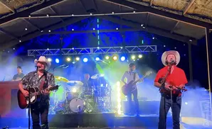 randy rogers band performing on stage in front of blue and yellow