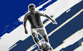 Soccer player dribbling a ball against a blue and white abstract background.
