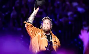 Rapper Jelly Roll raises his hat to the crowd during a performance.