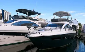 Two luxury yachts docked side-by-side, with a clear blue sky above.