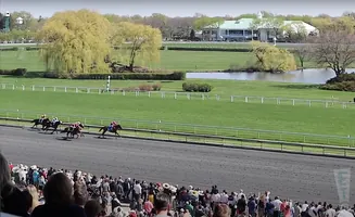 Horse race at Belmont Park with spectators in the foreground.