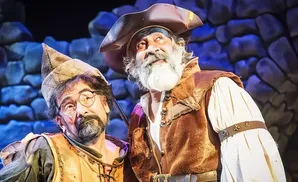 Two men in medieval costumes, one with glasses and a pointed hat, the other with a pirate hat and beard.
