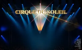 Cirque du Soleil logo on a stage with dramatic blue spotlights and a chandelier.
