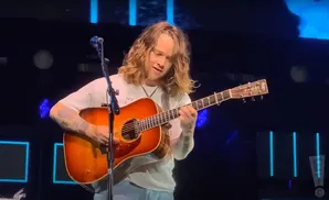 billy strings performing on stage playing the guitar