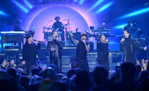 Backstreet Boys perform on stage with bright blue lighting and a live audience.