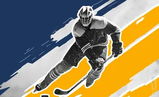 Hockey player in a black and white uniform skates with a stick, against a blue and yellow abstract background.