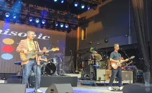 Musicians on stage with a banner that says 