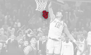 Basketball player in St. John's jersey #12 dunks the ball as the 