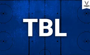 Top-down view of a blue hockey rink with white lines and markings, including a logo of crossed hockey sticks.