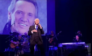 the righteous brothers singing on stage in a suit