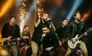 A band performs on stage with bright lights and sparklers.