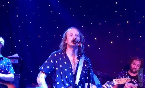 deer tick lead singer singing in a star shirt