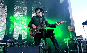 les claypool of primus playing the guitar live on stage