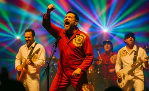 A band performs on stage with vibrant, colorful lights behind them.