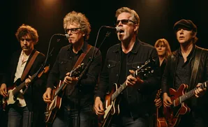 Band playing guitars on stage.