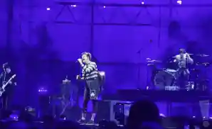 yungblud performing on stage with guitar on his back.