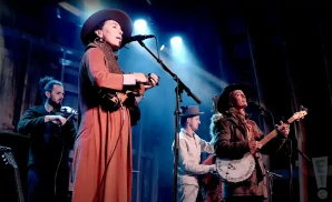 rising appalachia performing on stage in front of blue light