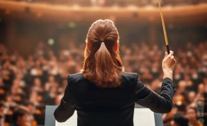 a photograph from behind classical conductor elim chan, performing in front of a large audience