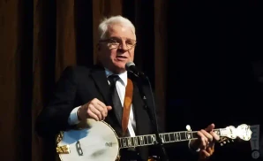 steve martin wearing a suit while playing the banjo
