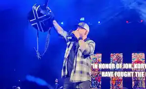 brantley gilbert holding his guitar up while performing on stage.