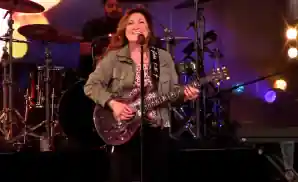 jo dee messina playing the electric guitar on stage.