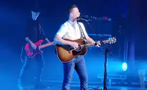 scotty mccreery performing on stage at the chandler center for the arts in chandler, arizona.