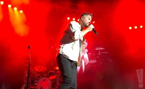 brett young performing live on stage in front of red lights