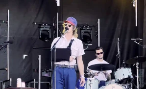 caamp performing on stage singer and drummer in shot