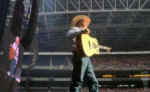 cody johnson on stage in a cowboy hat and holding a guitar at lumen field in seattle washington